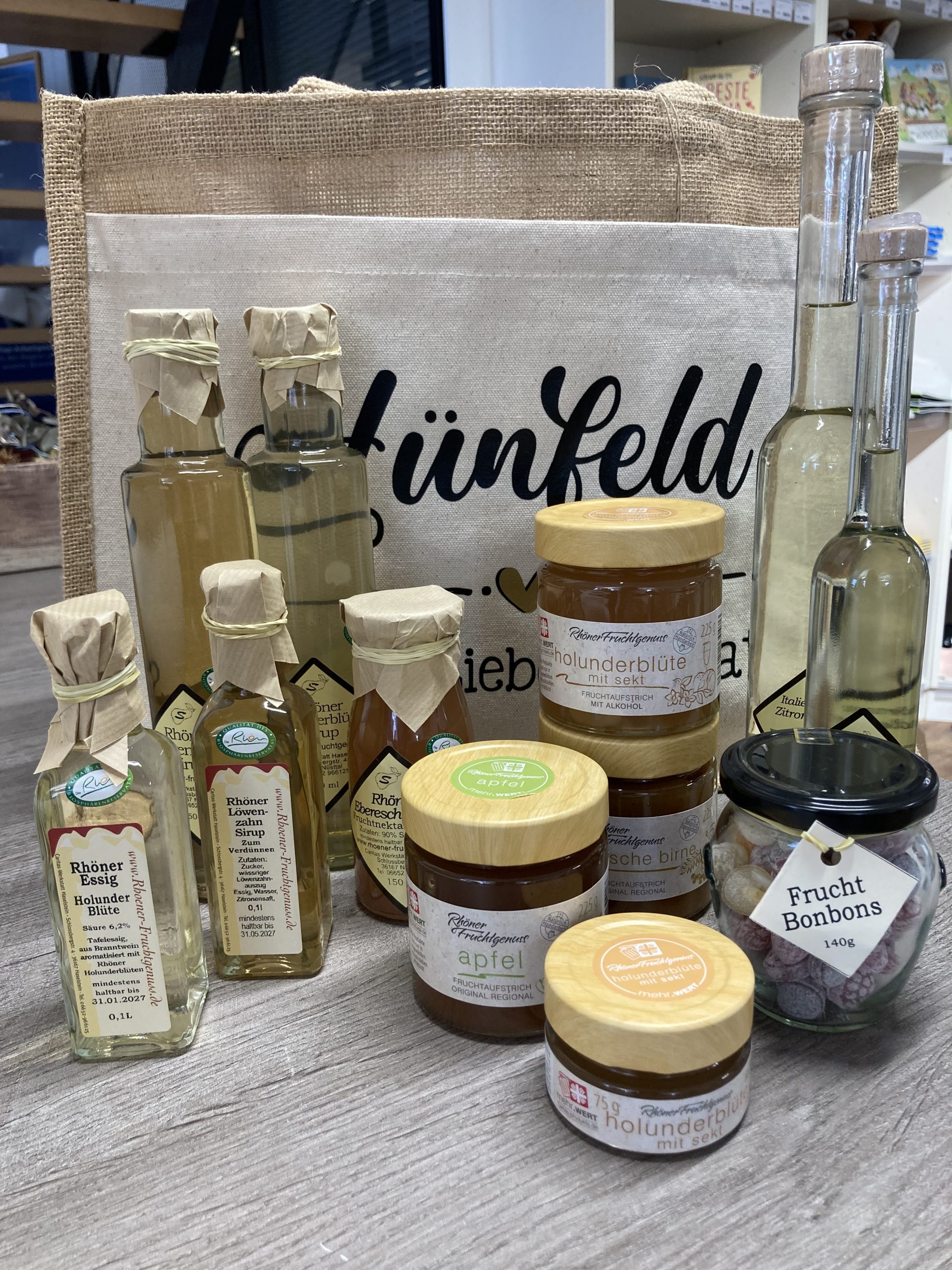 Zusammenstellung unserer Produkte, im Hintergrund eine Jutetasche mit Schriftzug Heimatliebe